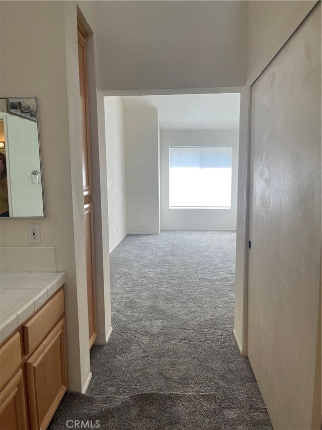 hall featuring dark colored carpet