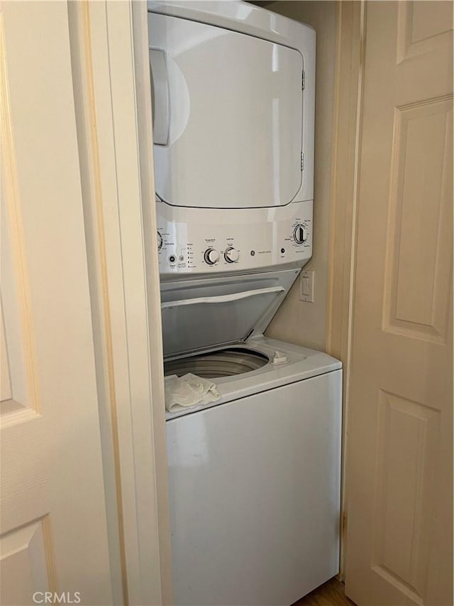 clothes washing area featuring stacked washing maching and dryer