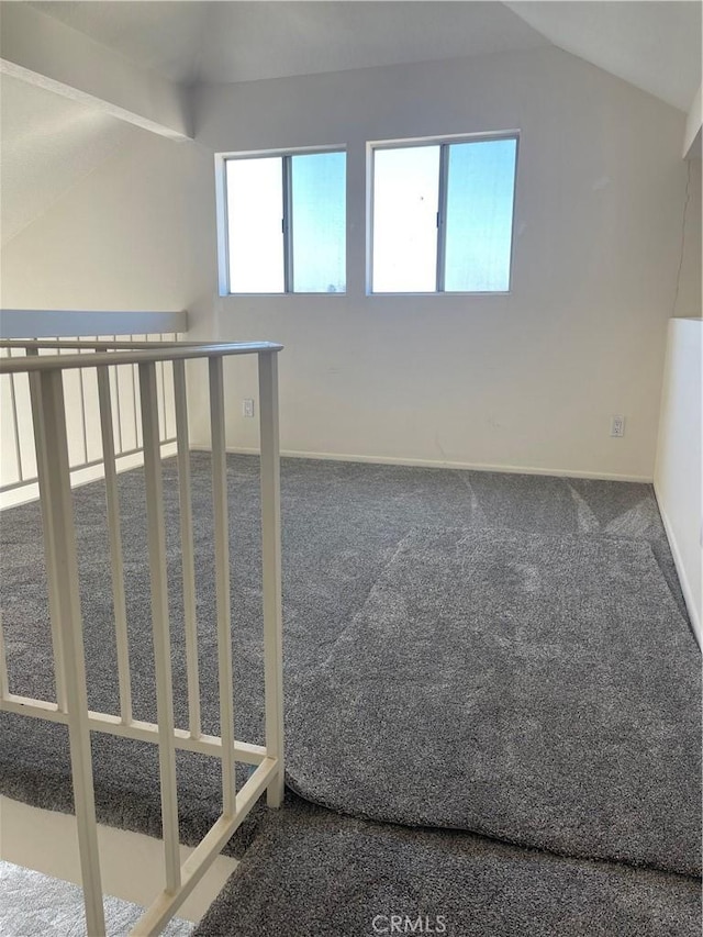 carpeted empty room featuring lofted ceiling