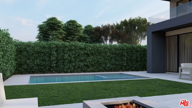 view of pool with a fire pit and a lawn