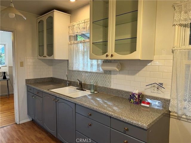 kitchen with backsplash, gray cabinets, dark wood-type flooring, and sink