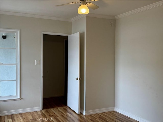 spare room with wood-type flooring, ceiling fan, and ornamental molding