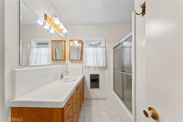 bathroom with vanity, tile patterned floors, decorative backsplash, enclosed tub / shower combo, and heating unit