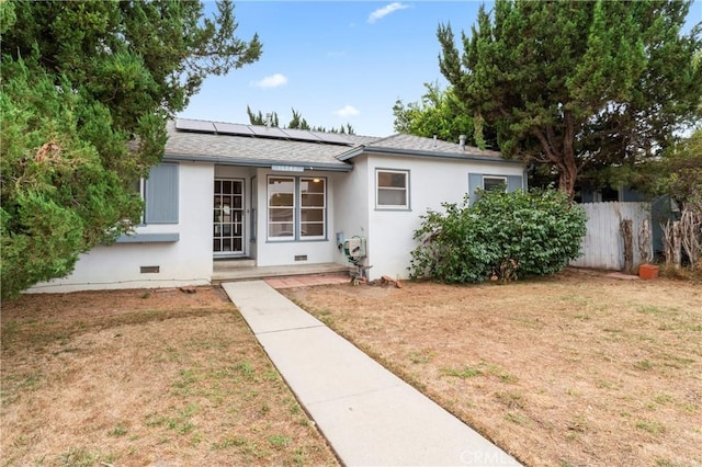 ranch-style house with a front yard and solar panels