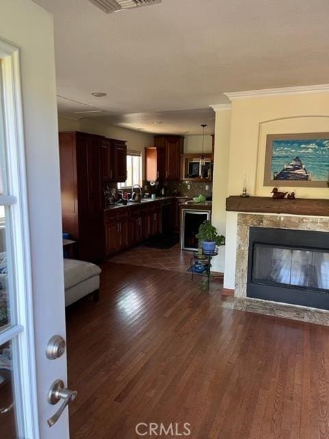 living room featuring dark hardwood / wood-style floors, ornamental molding, and sink