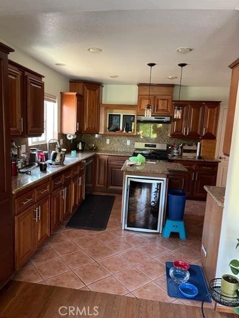 kitchen featuring sink, tasteful backsplash, wine cooler, pendant lighting, and stainless steel range with electric stovetop