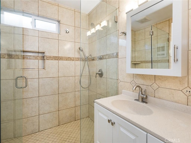 bathroom with vanity, tile walls, an enclosed shower, and backsplash