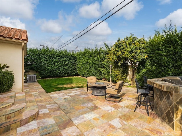 view of patio featuring a bar, an outdoor fire pit, and central air condition unit