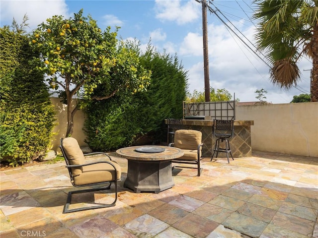 view of patio / terrace with an outdoor fire pit and a bar