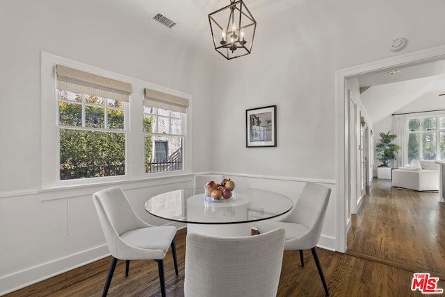 dining room featuring lofted ceiling, breakfast area, a chandelier, and dark hardwood / wood-style floors