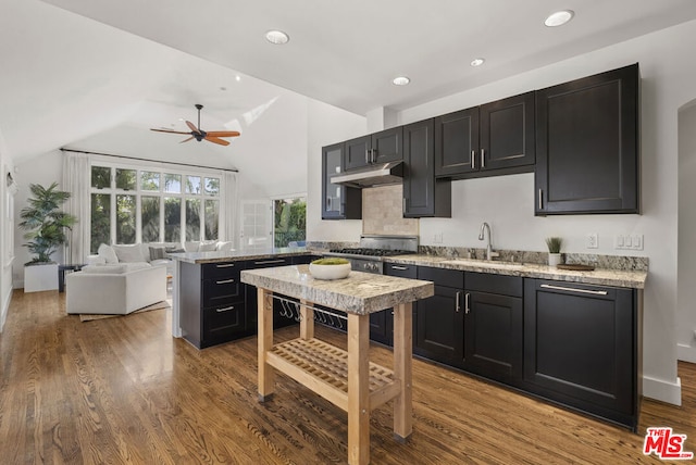 kitchen with light stone counters, ceiling fan, sink, light hardwood / wood-style floors, and lofted ceiling