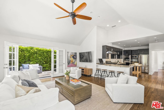 living room with ceiling fan, hardwood / wood-style floors, high vaulted ceiling, and french doors