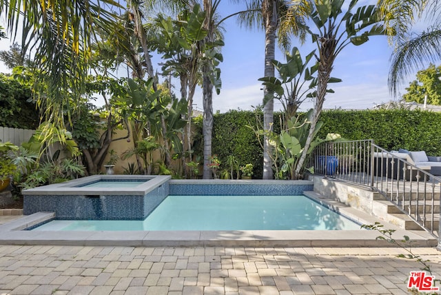 view of swimming pool featuring an in ground hot tub