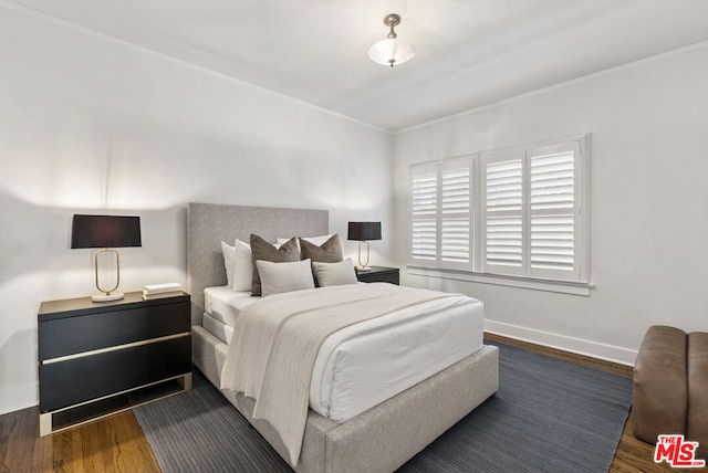 bedroom with dark wood-type flooring and ornamental molding