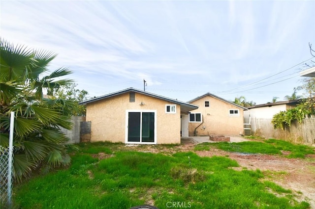 back of house featuring a fenced backyard and stucco siding