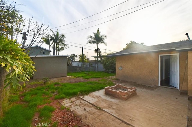 view of yard featuring fence, a fire pit, and a patio