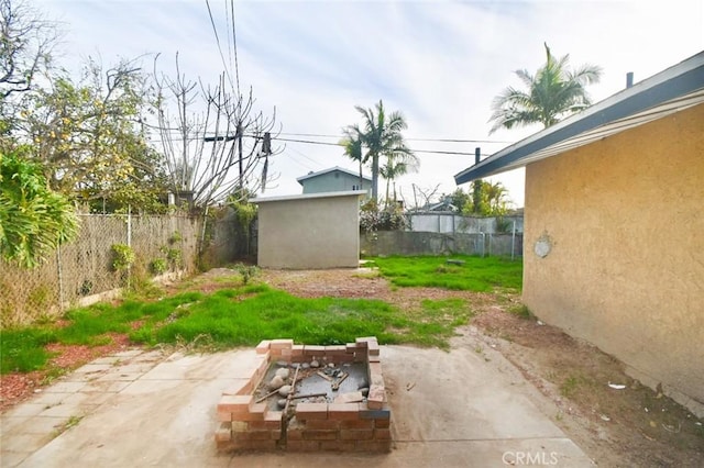 view of yard with a patio area, a fenced backyard, and an outdoor structure