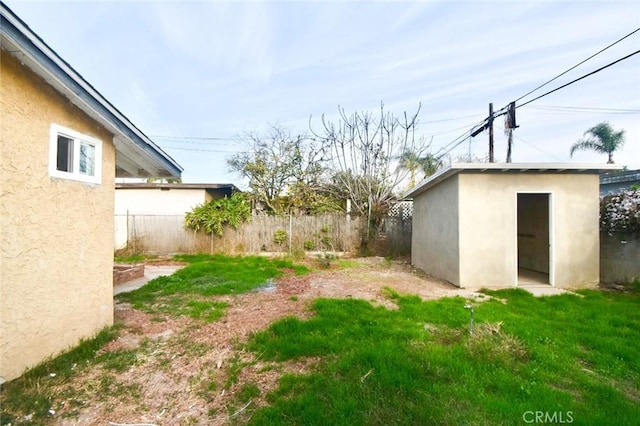 view of yard featuring an outbuilding and fence