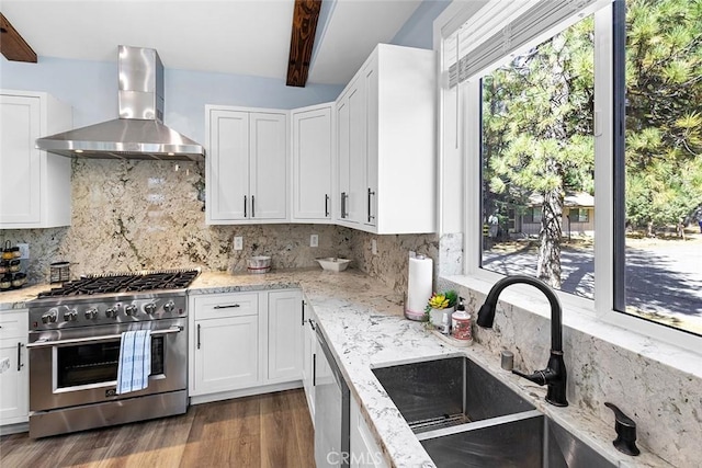 kitchen with wall chimney exhaust hood, sink, white cabinetry, and stainless steel appliances