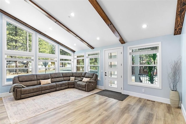 living room featuring light hardwood / wood-style flooring and lofted ceiling with beams