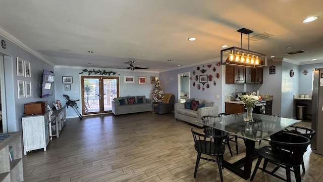 dining area featuring ceiling fan, french doors, ornamental molding, and hardwood / wood-style flooring