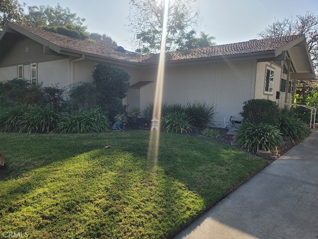 view of side of home with a lawn