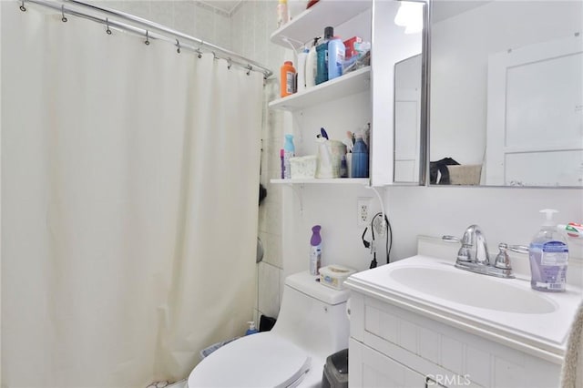 bathroom featuring walk in shower, vanity, and toilet