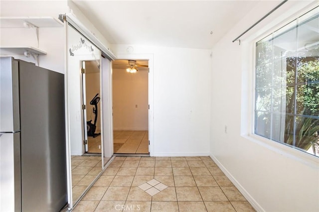 kitchen featuring stainless steel refrigerator, ceiling fan, and light tile patterned floors