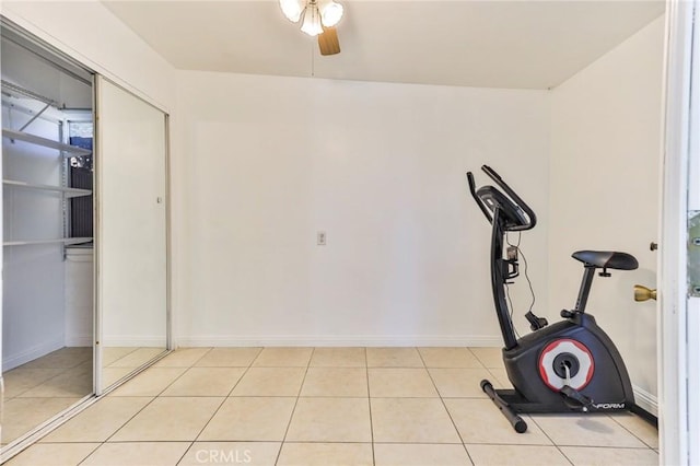 exercise area with ceiling fan and light tile patterned floors