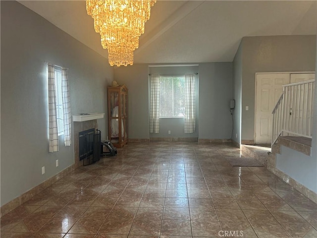 unfurnished living room with a fireplace, a chandelier, lofted ceiling, and tile patterned flooring