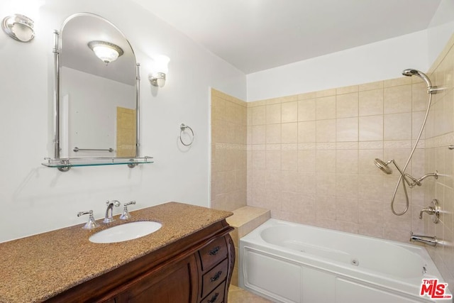 bathroom featuring tiled shower / bath combo and vanity