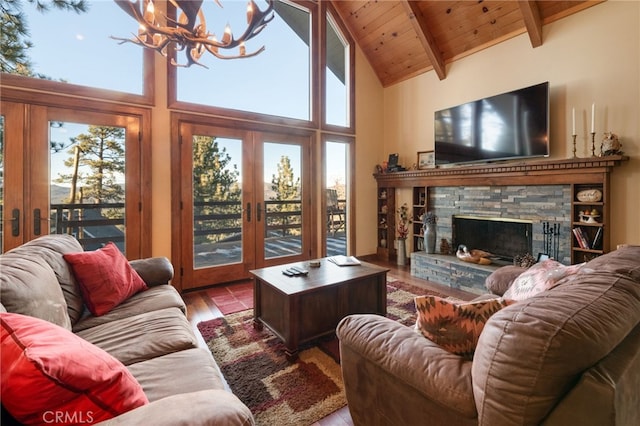 living room with a notable chandelier, a healthy amount of sunlight, beam ceiling, and french doors