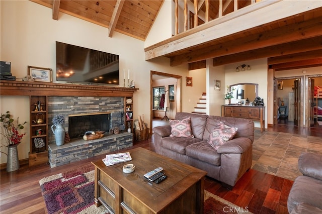 living room with wooden ceiling, dark wood-type flooring, high vaulted ceiling, a stone fireplace, and beam ceiling