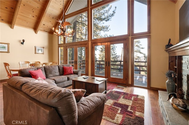 living room featuring french doors, high vaulted ceiling, a notable chandelier, beamed ceiling, and light hardwood / wood-style floors