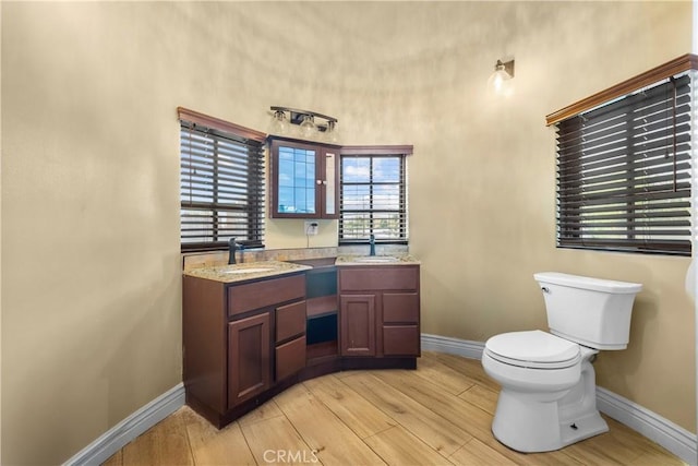 bathroom with toilet, vanity, and hardwood / wood-style flooring