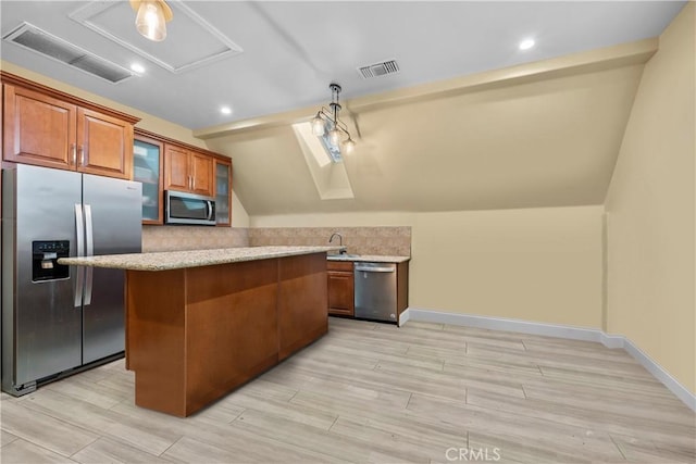 kitchen featuring light hardwood / wood-style floors, vaulted ceiling, and appliances with stainless steel finishes