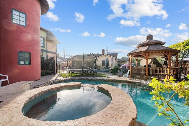 view of pool featuring an in ground hot tub, a gazebo, and a trampoline