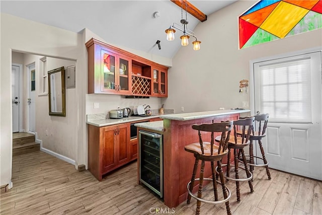 bar featuring lofted ceiling with beams, light hardwood / wood-style floors, hanging light fixtures, and beverage cooler