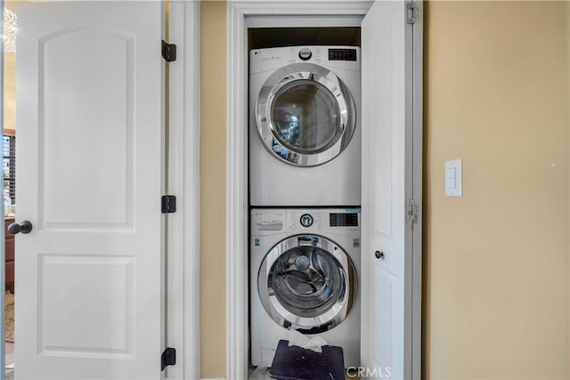 washroom featuring stacked washer / drying machine