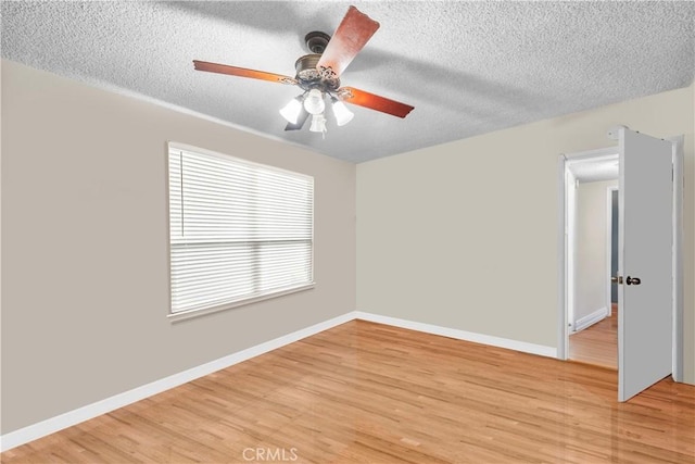 spare room with a textured ceiling and light wood-type flooring