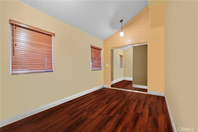 unfurnished room featuring dark hardwood / wood-style floors and vaulted ceiling