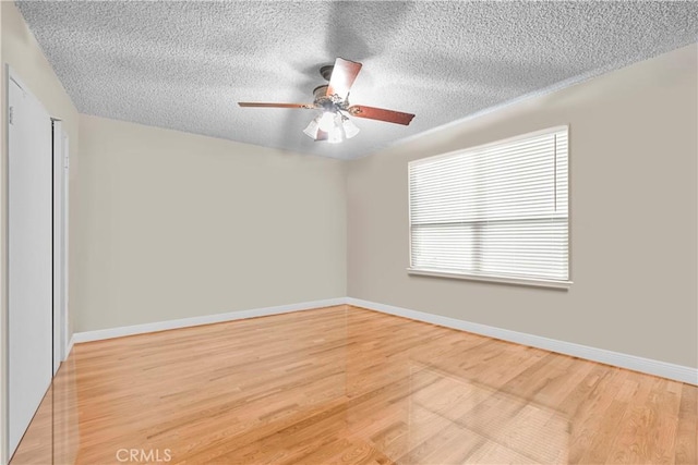 unfurnished room with hardwood / wood-style flooring, ceiling fan, and a textured ceiling