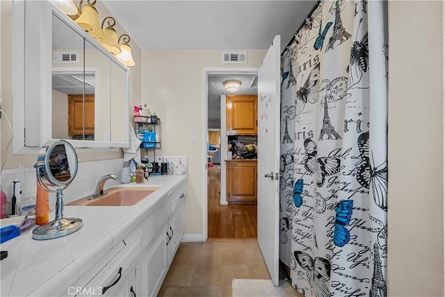 bathroom featuring tile patterned floors, vanity, curtained shower, and backsplash