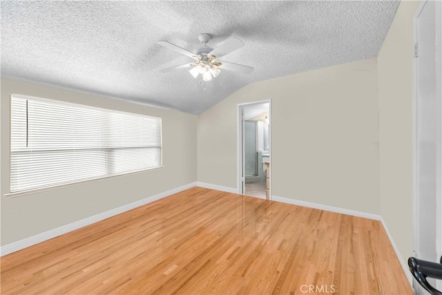 interior space with ensuite bath, ceiling fan, wood-type flooring, a textured ceiling, and vaulted ceiling