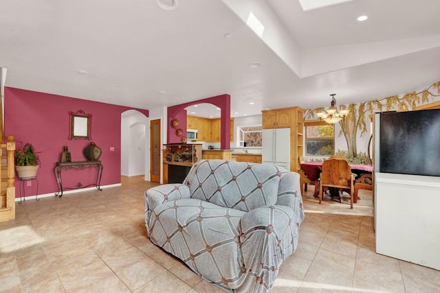 living room featuring lofted ceiling, light tile patterned floors, and a chandelier