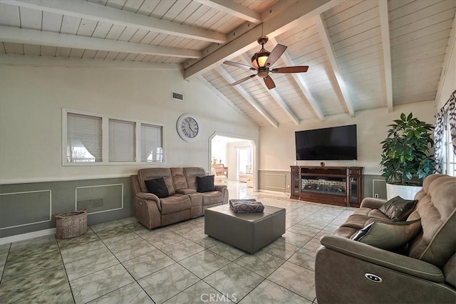 living room with vaulted ceiling with beams, ceiling fan, and a wealth of natural light