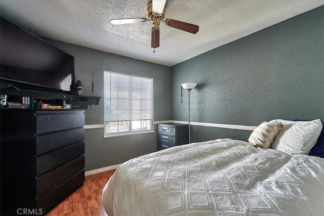 bedroom featuring a textured ceiling, hardwood / wood-style flooring, ceiling fan, and lofted ceiling