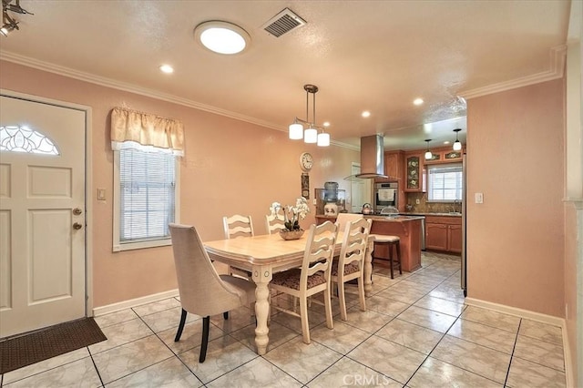 dining room with light tile patterned floors, crown molding, and sink