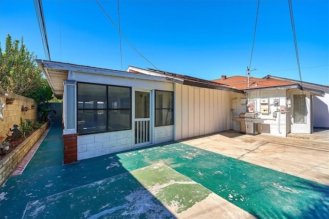 back of house featuring a sunroom and a patio area