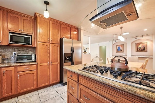 kitchen with pendant lighting, light stone counters, and appliances with stainless steel finishes